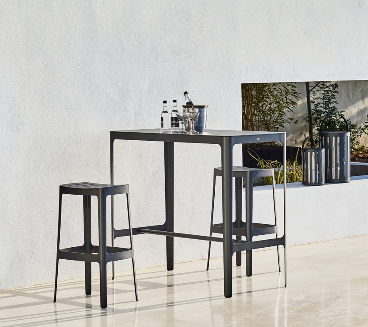 Cut bar table with Cut bar chairs by Cane-line