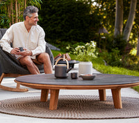 Aspect Coffee Table 144cm outdoor lifestyle with Peacock rocking chair by Cane-line