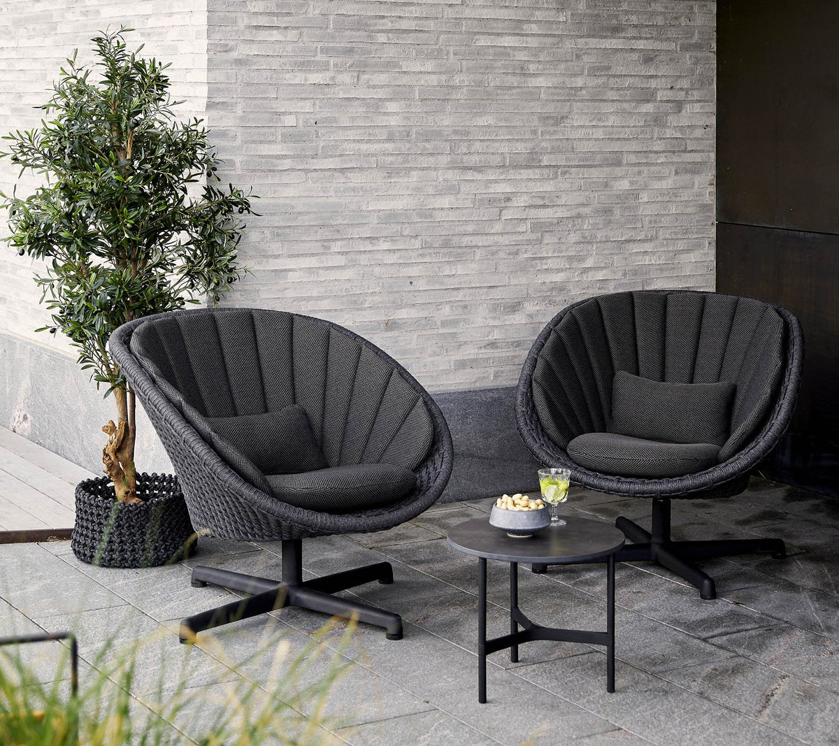 Peacock lounge chair with swivel aluminium base lifestyle by Cane-line