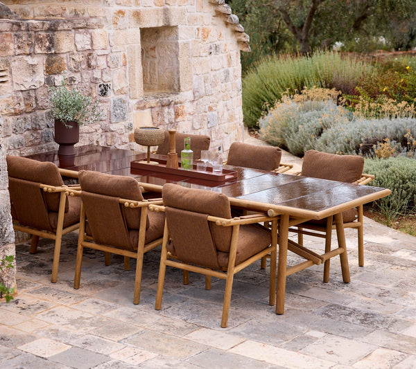 Sticks armchair cushion set shown with Sticks armchair and dining table by Cane-line