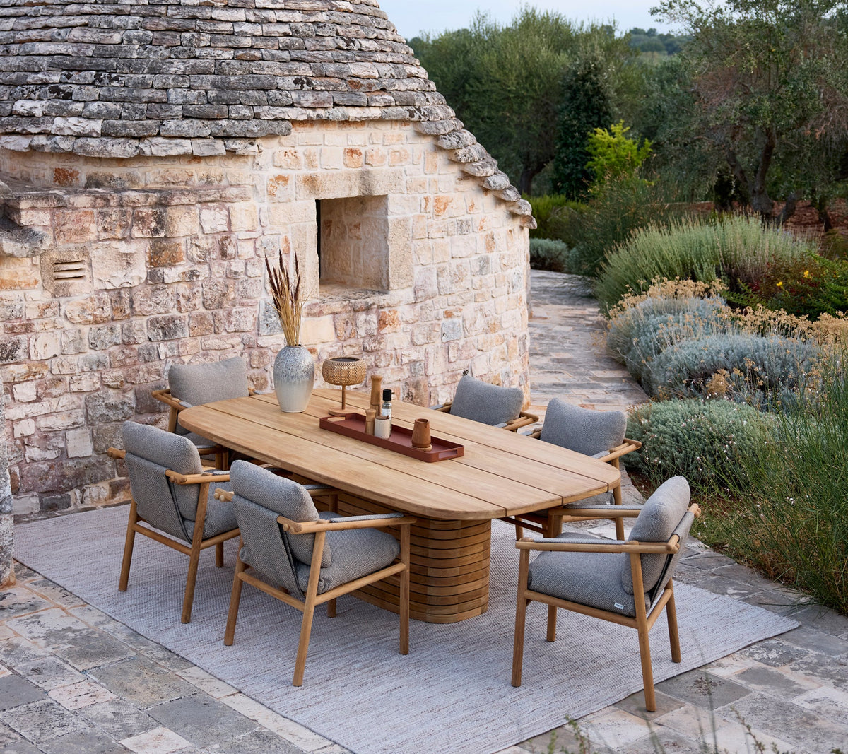 Sticks armchair cushion set shown in an outdoor dining setting by Cane-line