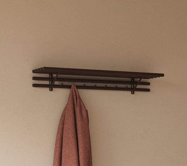 Sticks coat rack with hat shelf in an indoor setting