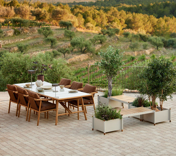 Sticks planter bench in an outdoor dining setting by Cane-line