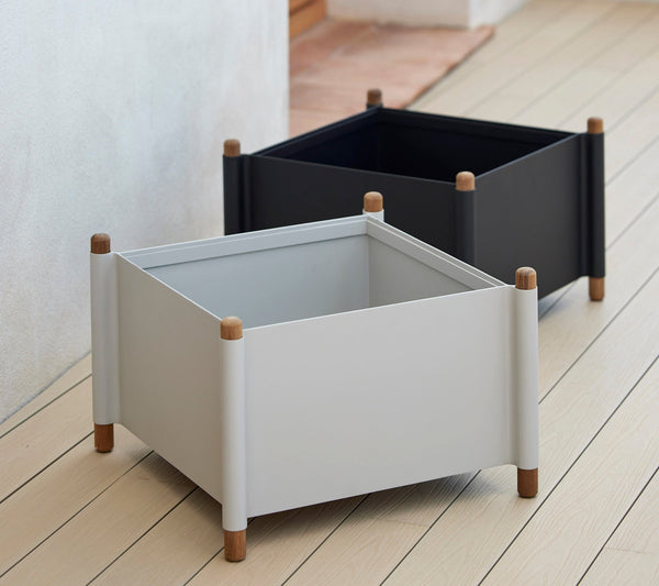 Sticks planter legs supporting planters in lava grey and sand by Cane-line