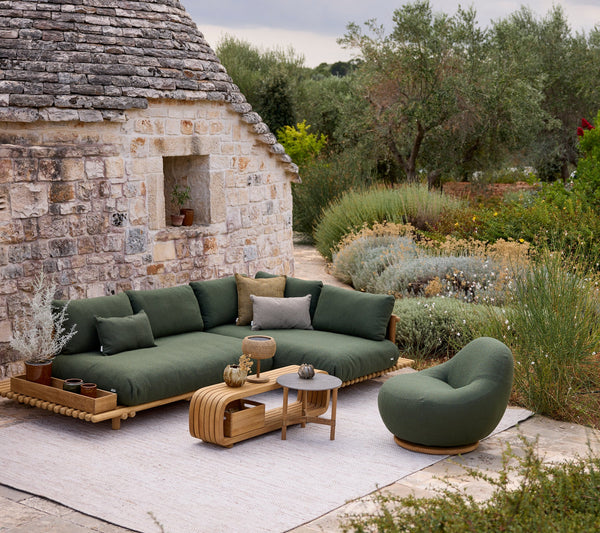 Sticks platform corner sofa lifestyle image with Gem lounge chair and Mellow coffee table by Cane-line
