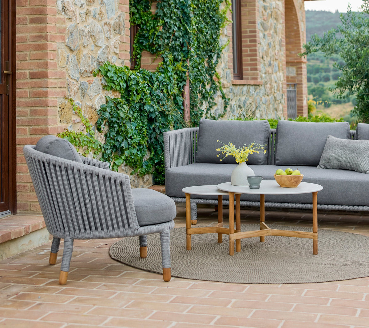 Cane-line Twist coffee table beside a lounge chair
