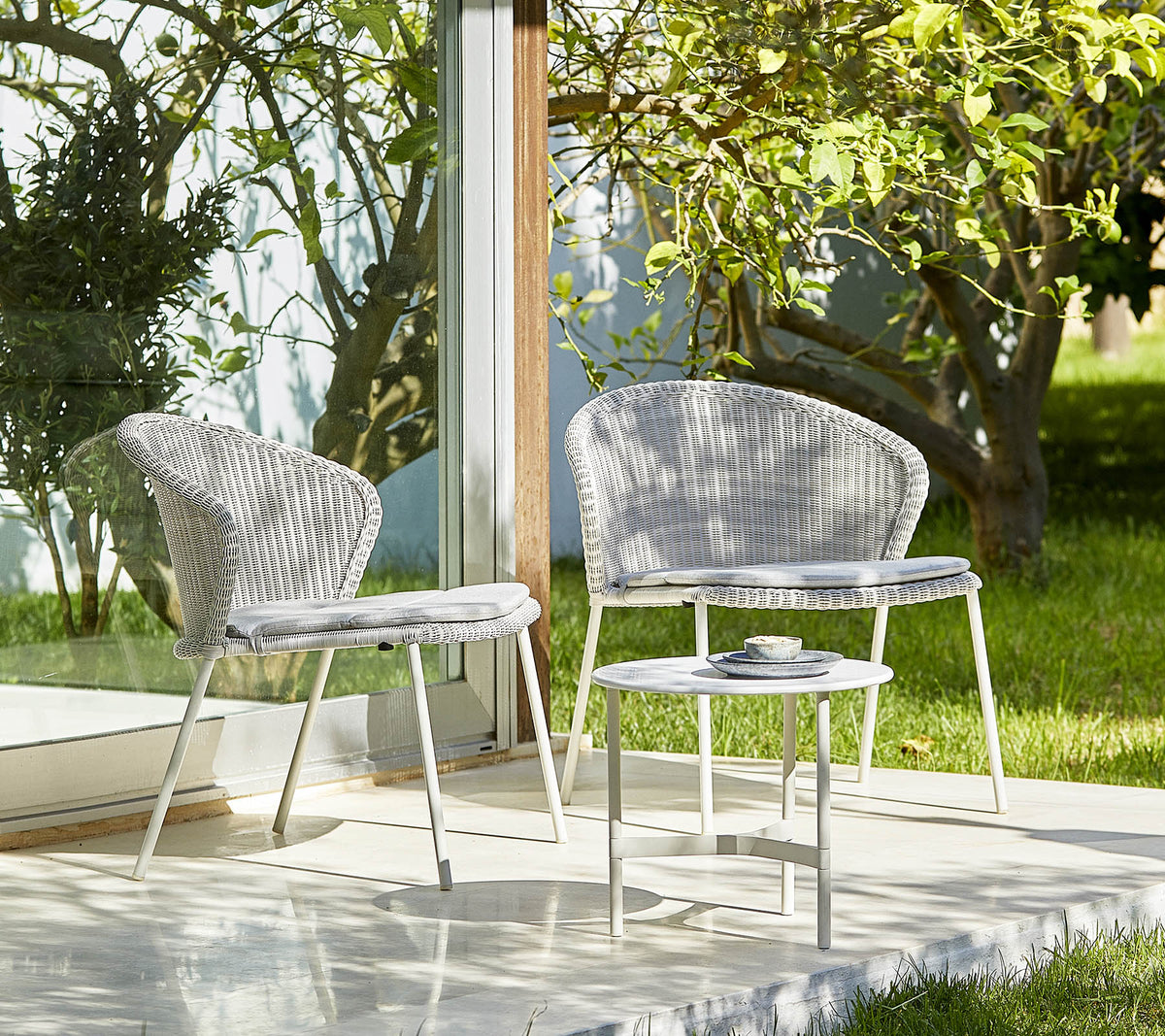 Cane-line Twist coffee table in a light outdoor setting