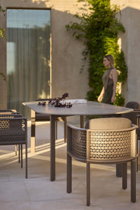 Gandia Blasco Arco Dining Armchair in Bronze at an outdoor dining table