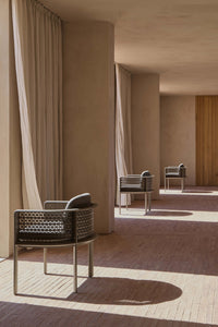 Gandia Blasco Arco Dining Armchair in Bronze in an architectural setting