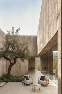 Lenis outdoor lounge chairs and coffee table by SKLD Studio in a modern courtyard