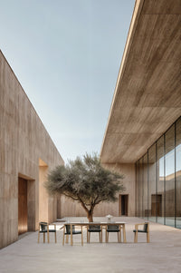 Lenis outdoor dining table and dining chairs by SKLD Studio in a modern courtyard