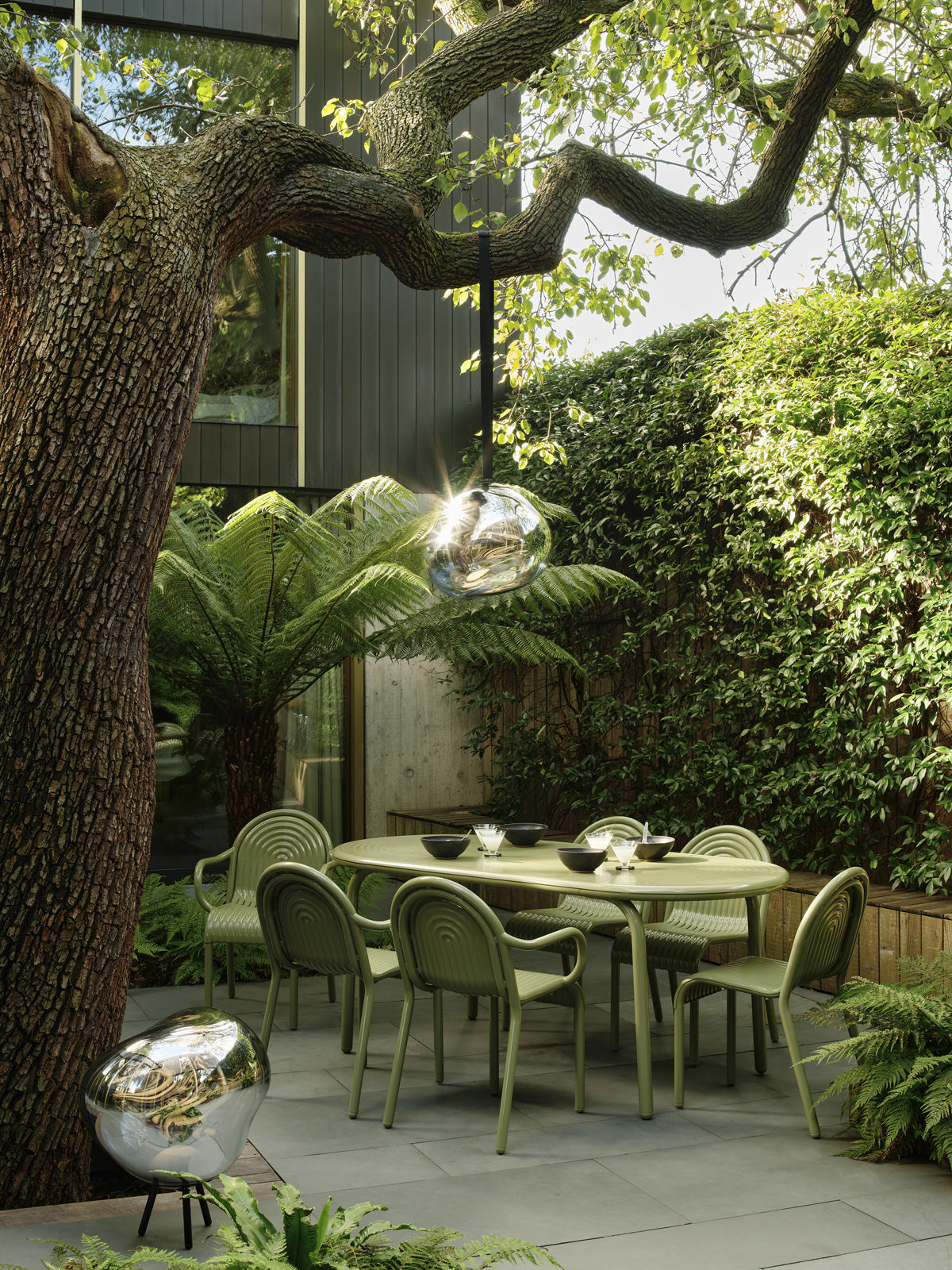 Melt Large Portable Light Nickel Polished Polycarbonate floor light by Tom Dixon in a modern outdoor setting