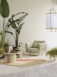 Roberti Armàn lounge chair with coffee tables in a covered setting