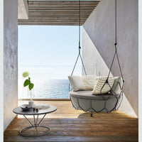 Roberti Gravity 9881 hanging sofa with Gravity 9885 coffee table in a covered outdoor setting