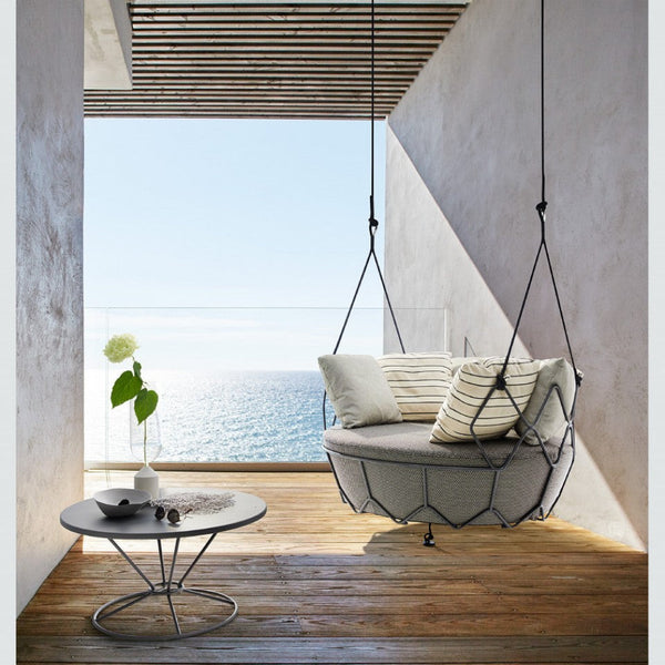 Roberti Gravity 9885 coffee table with Gravity 9881 hanging sofa in a covered outdoor setting