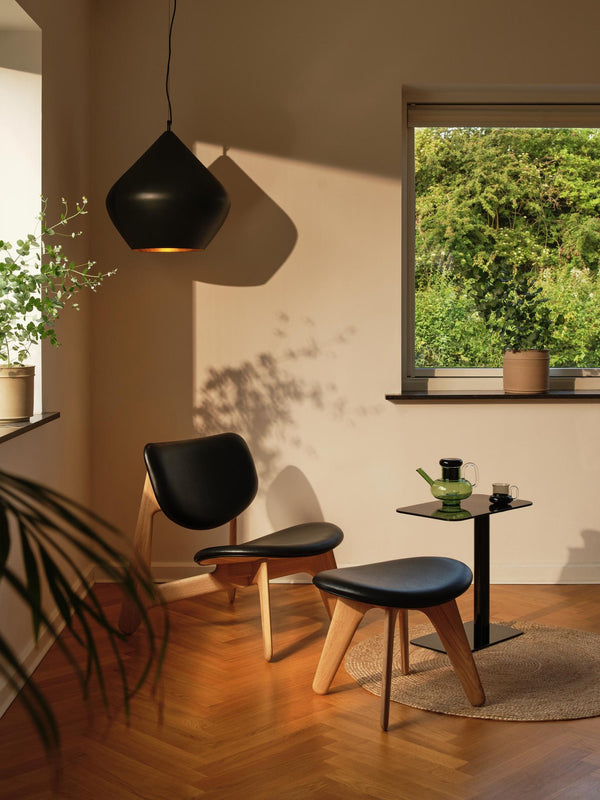 Tom Dixon Beat Fat Pendant in Matt Black Brass in a sunlit lounge