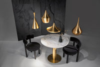 Tom Dixon Beat pendants in polished brass above a dining table