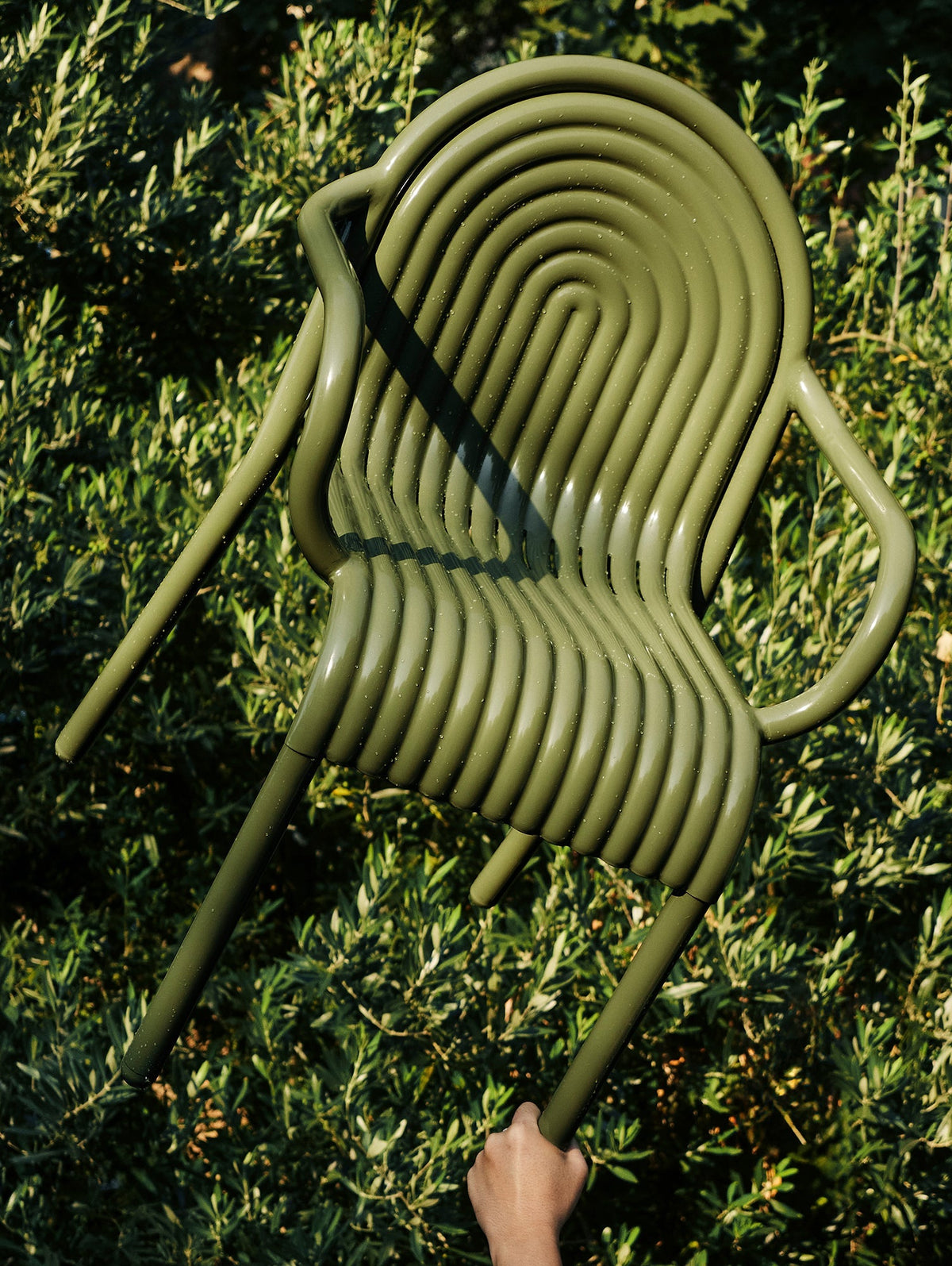 Tom Dixon Groove Outdoor Arm Chair in an outdoor lifestyle setting