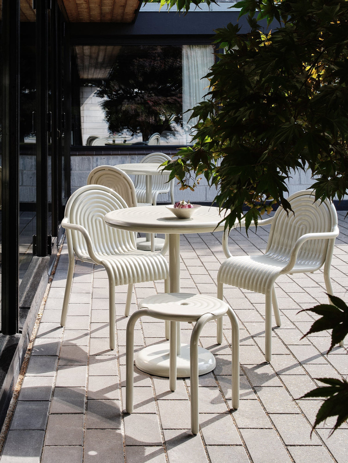 Tom Dixon Groove Outdoor Arm Chair in an outdoor lifestyle setting