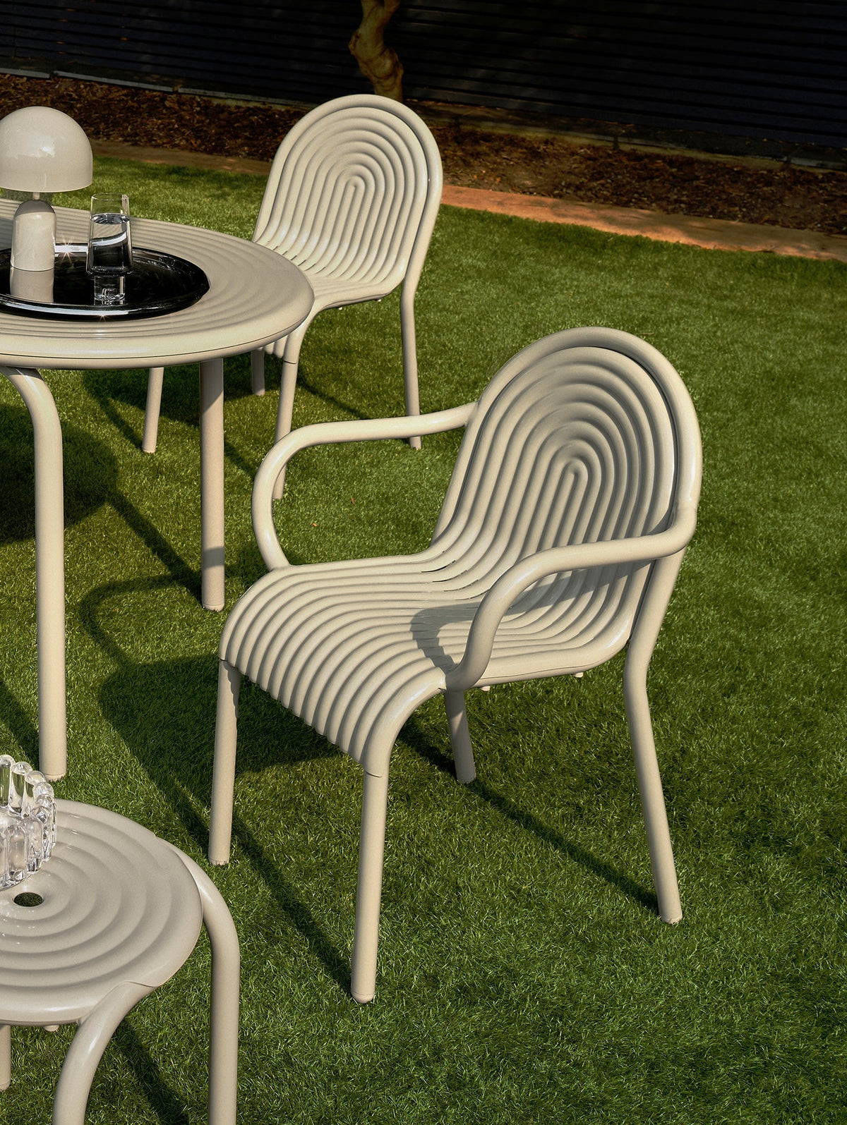 Tom Dixon Groove Outdoor Arm Chair in an outdoor lifestyle setting