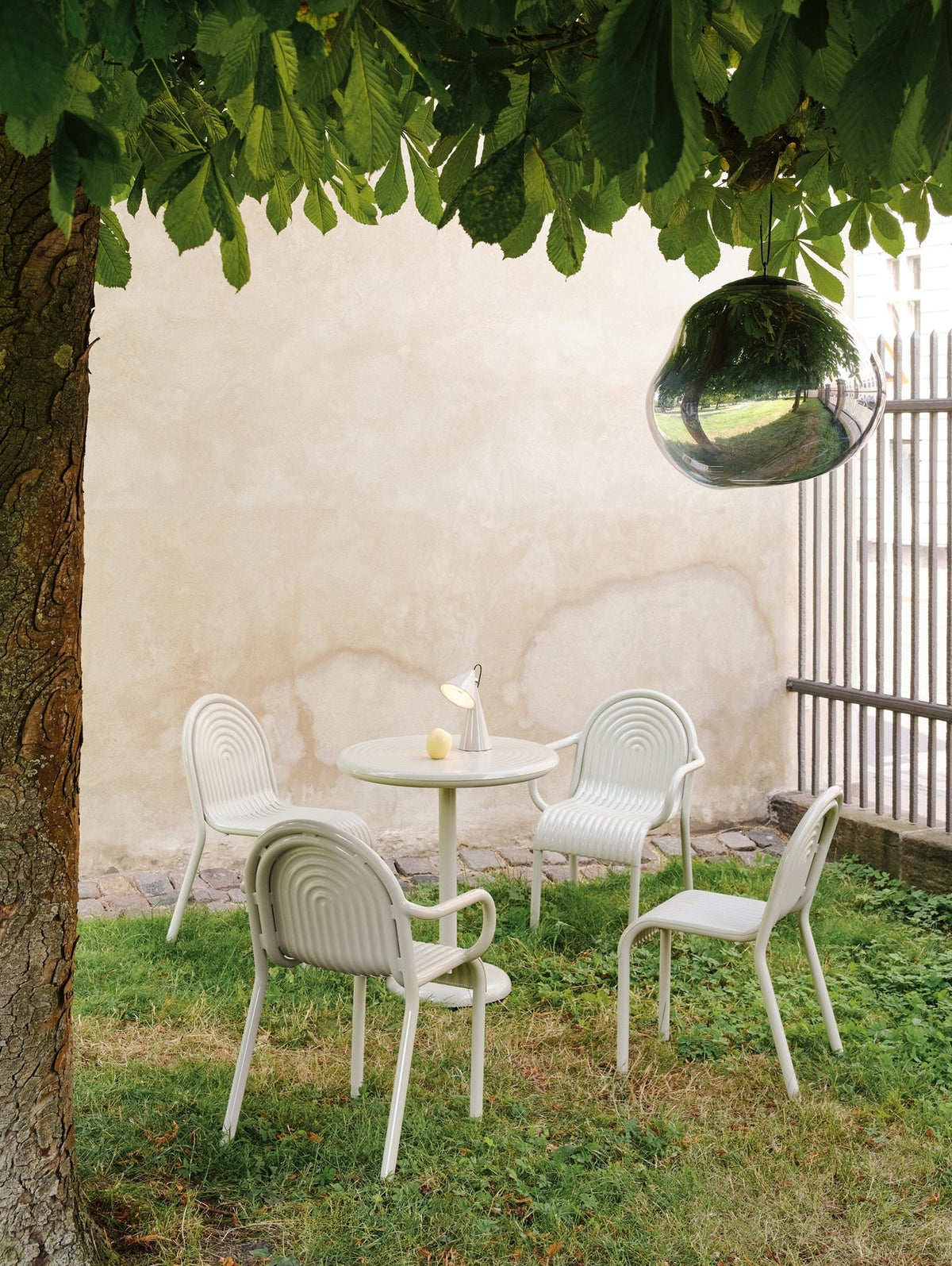 Tom Dixon Groove Outdoor Arm Chair in an outdoor lifestyle setting