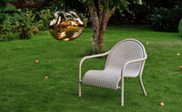 Tom Dixon Groove Outdoor Lounge Chair in a garden lifestyle setting