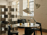 Tom Dixon Pose Pendants in Polished Silver above a dining table