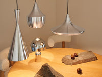 Tom Dixon Unbeaten pendant family above a modern dining table
