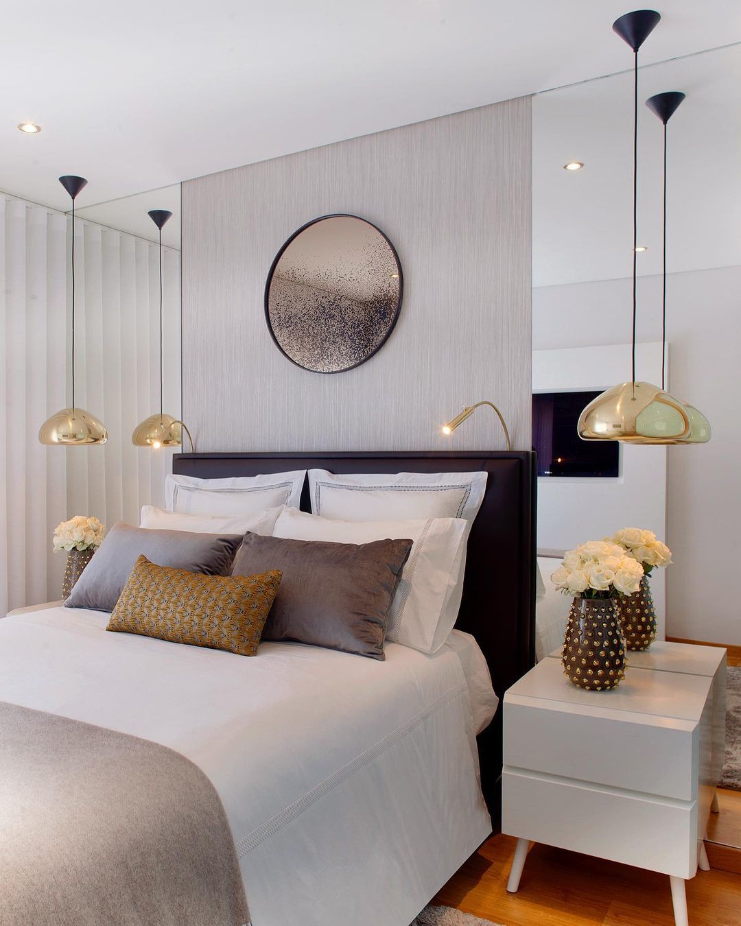 Tom Dixon Void Medium Pendant in polished brass beside a modern bed