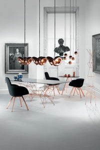 Tom Dixon Void copper pendants above a modern dining table