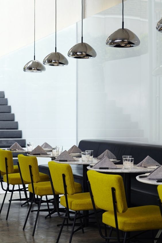 Tom Dixon Void Medium steel pendants above a modern dining area